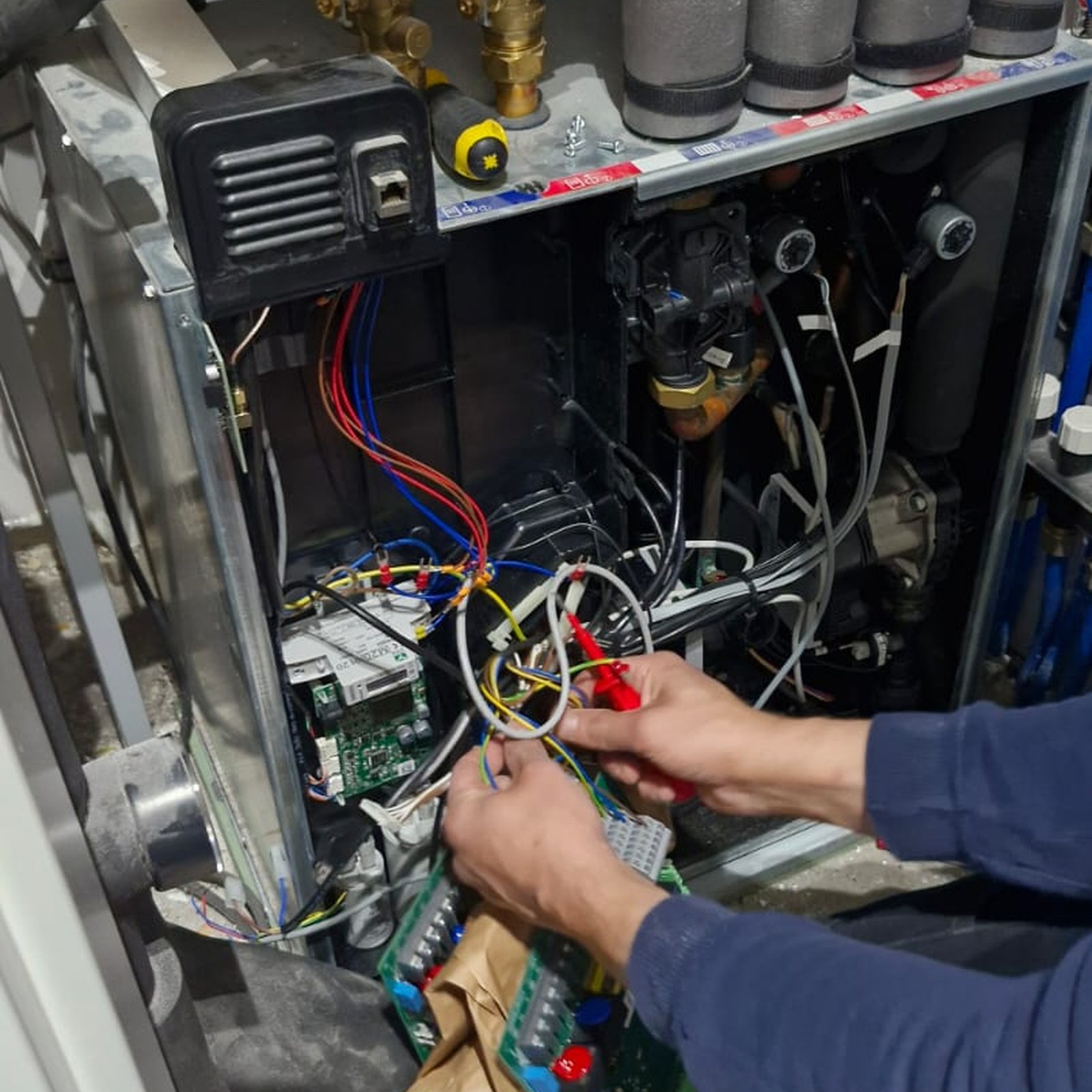 Vakman controleert de elektrische bedrading van een cv-installatie