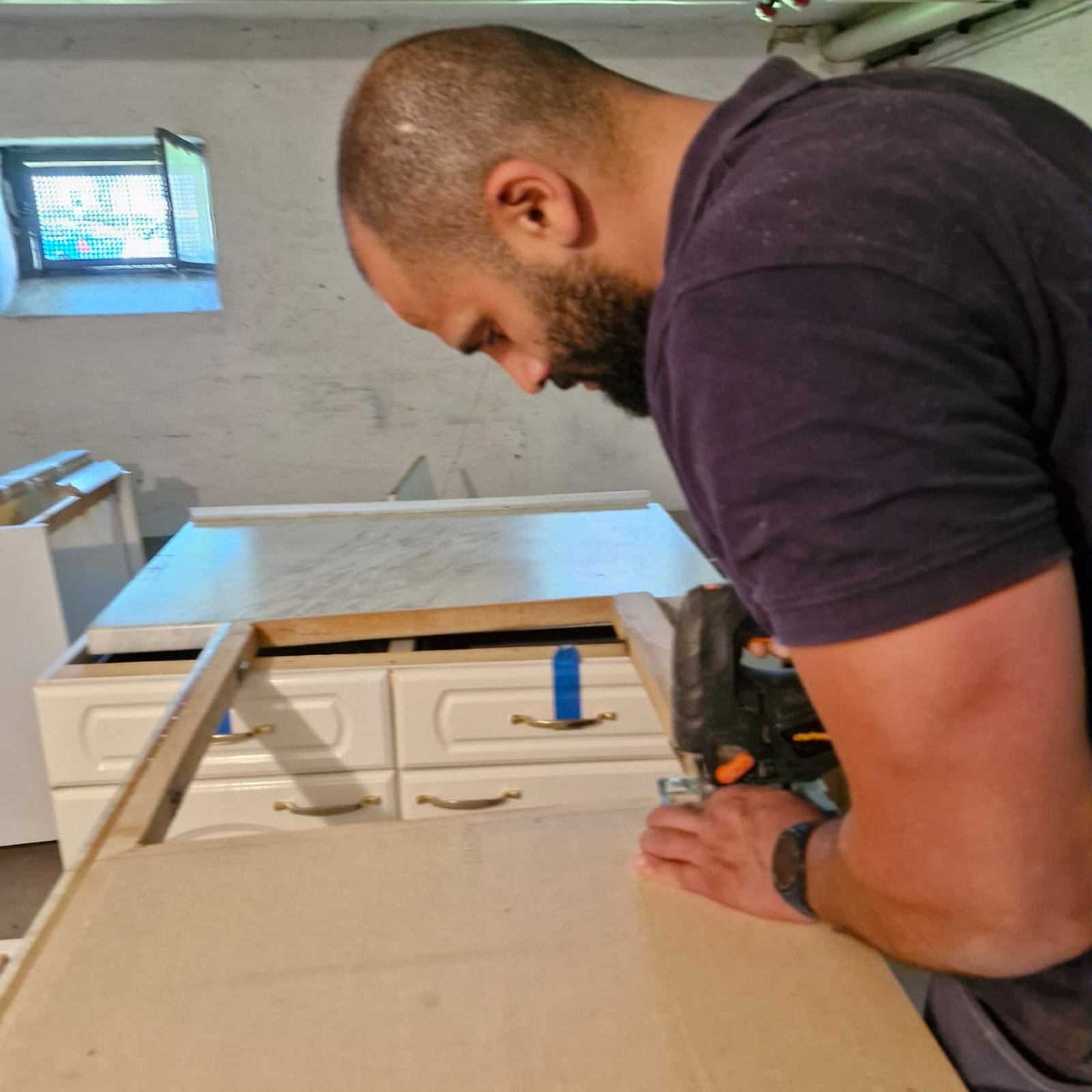 Vakman zaagt een keukenwerkblad op maat tijdens keukenmontage