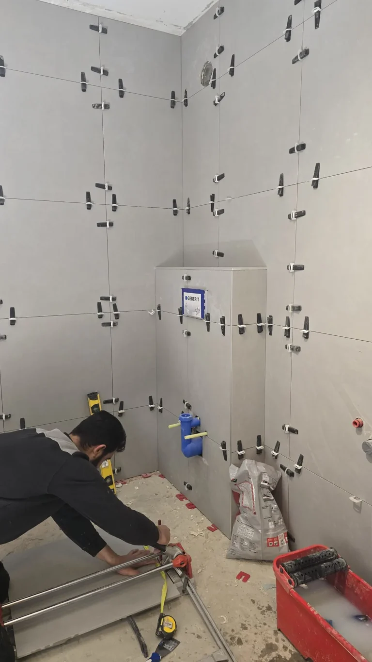 Vakman plaatst grote wandtegels in badkamer tijdens renovatie in Gorinchem